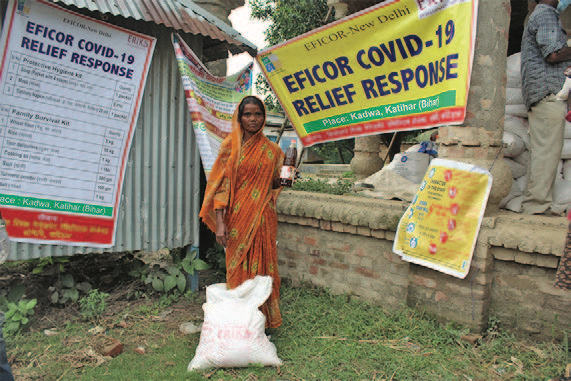 A girl by an EFICOR sign displaying the COVID crisis response in India.