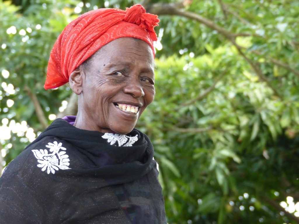 A woman wearing a red head scarf and black blouse with white decorations