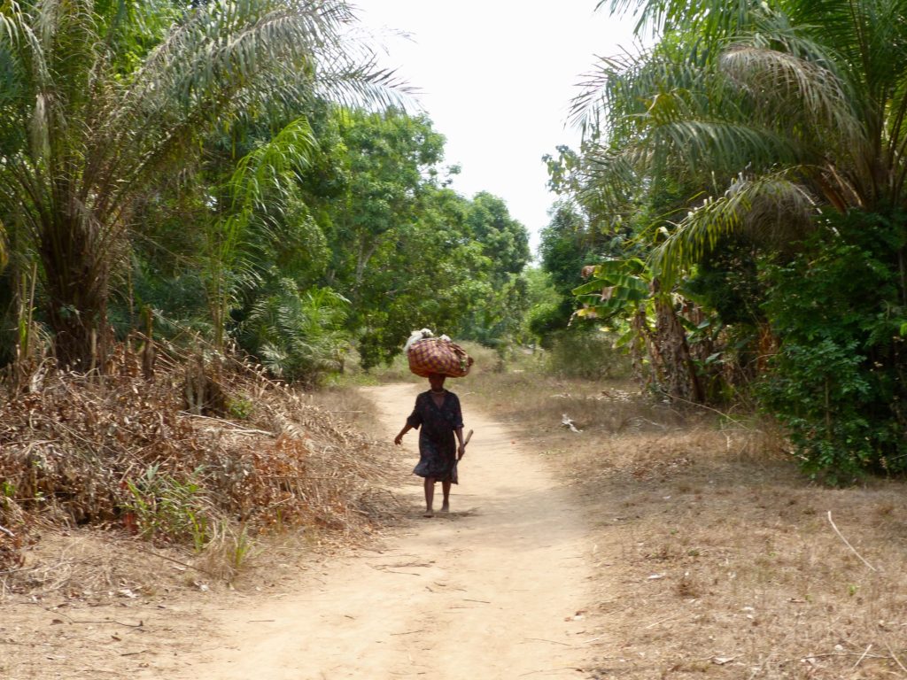 A woman walking in Sierra Leone with a bundle on her head