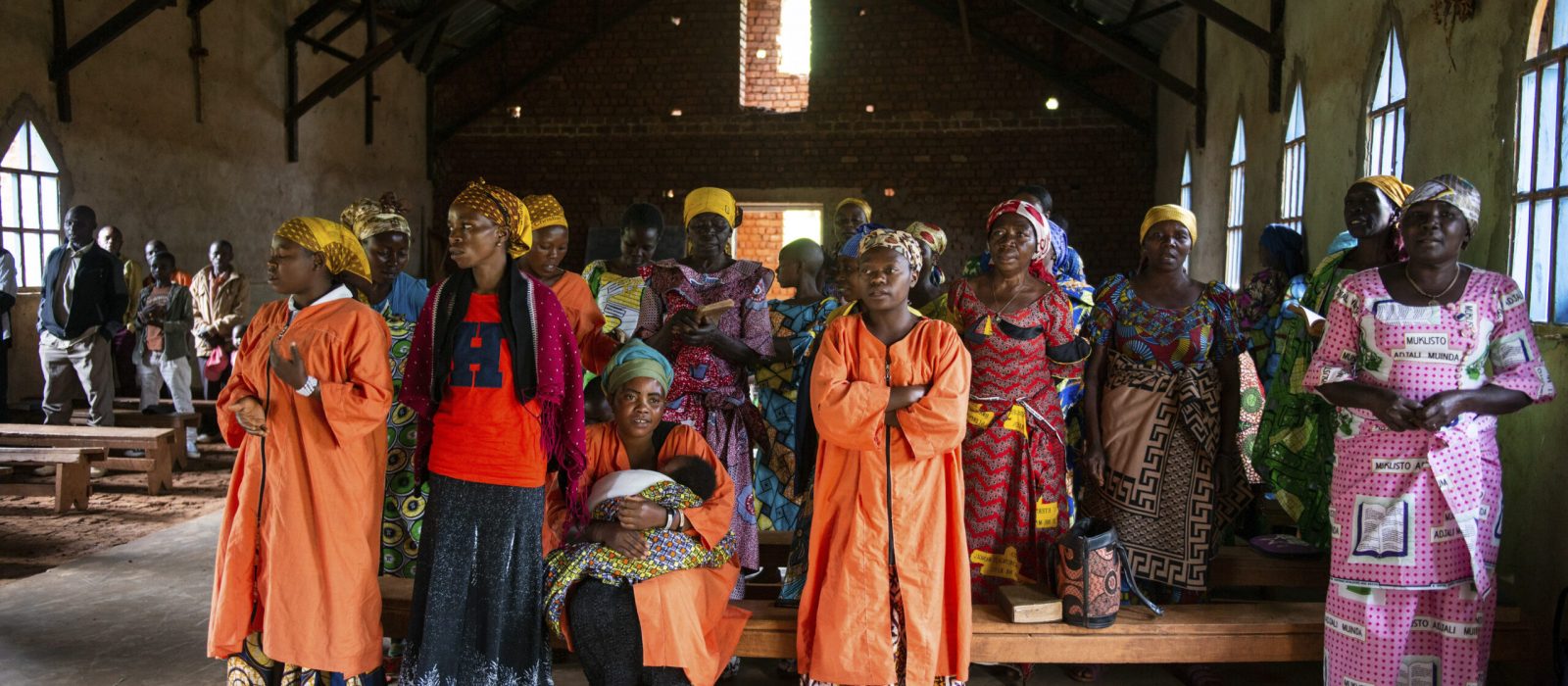 Women stand in a church service held in the parish of Kiwata village, Butembo, Democratic Republic of Congo, on 12 December 2021. Tearfund Canada continues to support several training and outreach programmes, with the help of CBCA, in the Democratic Republic of Congo in order to assist vulnerable communities out of poverty.