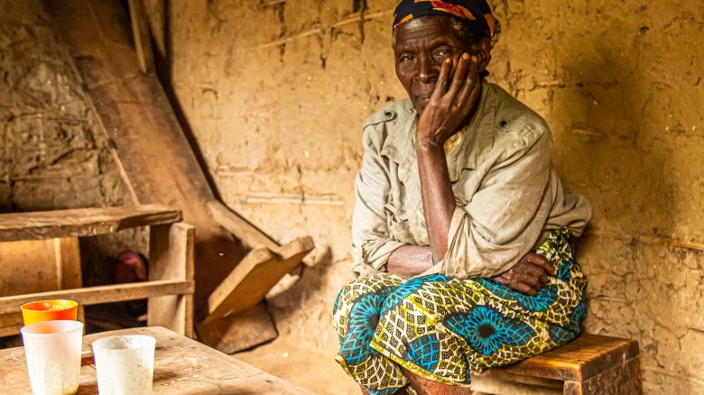 Kyakimwa Nzamba Florence, widow (mother of 8 children) and farmer, poses for a photo inside of her house in Lukkanga, DRC.  She is seeking to join the Kimbulu Bashu Food Security project

"When I see others spending their day in their fields, whether growing cabbages or other crops, I ask myself: when did they start? Like a neighbor here, I love it when they spend their day in their fields, and today, their lives have changed thanks to this project.