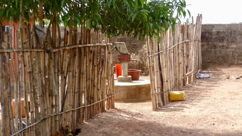 A bamboo fence with a well behind it